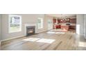 Bright living room with hardwood floors, a fireplace, and an open layout to the kitchen with stainless appliances at 5805 Lindley Crescent Dr, Indian Trail, NC 28079