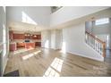 Spacious living room with high ceilings, hardwood floors, and lots of natural light, with a modern kitchen in view at 5805 Lindley Crescent Dr, Indian Trail, NC 28079