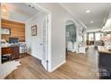 Bright home entryway featuring wood-look floors, a decorative archway, and views into the living room at 6243 Kilchurn Dr, Indian Land, SC 29707