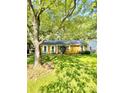 Charming home featuring a well-maintained yard, complemented by mature trees and quaint white shutters at 6832 Delta Lake Dr, Charlotte, NC 28215