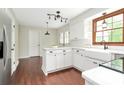 A bright kitchen featuring white cabinets, stainless steel appliances, an island and hardwood floors at 7020 Leesburg Rd, Charlotte, NC 28215