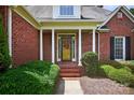 Inviting brick front porch with white columns and a charming entrance at 803 Woodmoore Ln, Kannapolis, NC 28081