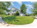 Landscaped lot featuring mature tree, lush green grass, and classic light gray siding at 9664 Littleleaf Dr, Charlotte, NC 28215