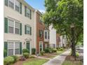 Charming townhome with brick facade, white siding, green shutters, and landscaped front yard at 9728 Blossom Hill Dr, Huntersville, NC 28078
