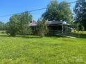 Quaint brick home surrounded by mature trees and a sprawling green yard at 10010 Stokes Ferry Rd, Gold Hill, NC 28071