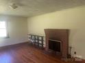 Cozy living room featuring hardwood floors, a brick fireplace, and natural light at 10010 Stokes Ferry Rd, Gold Hill, NC 28071