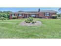 Charming brick home featuring a welcoming front porch and a beautifully landscaped yard at 116 Deer Trail Rd, Statesville, NC 28677