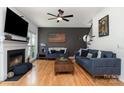 Cozy living room with hardwood floors, fireplace, dark accent wall, and comfortable blue sofas at 11624 Crossroads Pl, Concord, NC 28025