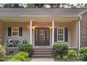 Inviting front porch with classic columns and seating, framing a decorative front door and lush landscaping at 1313 Western Hills Ln, Vale, NC 28168