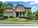 Charming stone home featuring a well-manicured lawn and professional landscaping at 16402 Doves Canyon Ln, Charlotte, NC 28278