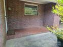 Cozy, covered brick porch featuring classic brickwork flooring, creating an inviting outdoor space at 165 Fieldstone Farm Dr, Statesville, NC 28625