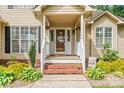 Close-up of the welcoming front porch with decorative plants and a cheerful 'hello' wreath at 1701 Whitney Ln, Salisbury, NC 28146