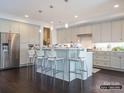Open concept kitchen with gray cabinets, a long island with barstool seating, and stainless steel appliances at 2008 Thatcher Way, Fort Mill, SC 29715