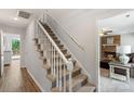 Carpeted staircase with white railings leads to the upper level, providing an elegant transition at 2012 Killarney Pl, Charlotte, NC 28262