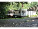White raised home with a wrap-around porch, two-car garage and lush lawn at 220 Singing Pine Dr, Clover, SC 29710