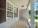 Inviting covered front porch with classic support columns, neutral siding, and a secure screen door at 2239 Blue Hampton Ln, Charlotte, NC 28213