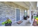 Charming covered front porch with stone detailing and comfortable seating at 240 Orson Oaks Ln, Pineville, NC 28134