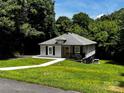 This cute home features a well-maintained lawn with mature trees providing ample shade and privacy at 305 E Henry St, Belmont, NC 28012