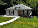 Well-kept home surrounded by a vibrant green lawn and mature trees, creating a peaceful and inviting atmosphere at 305 E Henry St, Belmont, NC 28012
