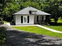 An inviting home featuring manicured lawn, neat gray siding and a cozy front porch with black railings at 305 E Henry St, Belmont, NC 28012