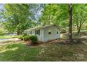 Side view of the house showing the lush landscaping and surrounding greenery at 3724 Patricia Nw Dr, Concord, NC 28027