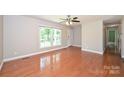 Bright living room featuring hardwood floors, a ceiling fan, and a large window at 3729 Woodleaf Rd, Charlotte, NC 28205
