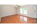 Bright living room with hardwood floors, ceiling fan, and large windows at 3729 Woodleaf Rd, Charlotte, NC 28205