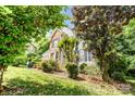 Landscaped front yard with mature trees and foundation plantings providing shade and curb appeal at 5238 Downing Creek Dr, Charlotte, NC 28269