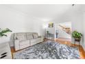 Bright living room featuring a plush couch, hardwood floors, and a neutral color palette at 5302 Fairgrove Ln, Harrisburg, NC 28075