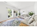 Airy living room boasts large windows, hardwood floors, and comfortable seating area at 5302 Fairgrove Ln, Harrisburg, NC 28075