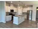 Modern kitchen features white cabinetry, granite countertops, stainless steel appliances, and a center island at 5337 Orchid Bloom Dr, Indian Land, SC 29707