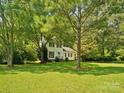 Attractive two-story house surrounded by mature trees and a spacious, well-maintained front lawn for a peaceful setting at 5828 Wilora Lake Rd, Charlotte, NC 28212