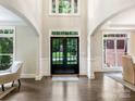 Grand foyer with high ceilings, a dark hardwood floor, and a statement front door at 610 Hampshire Hill Rd, Matthews, NC 28105