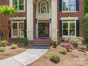 Inviting front entry with brick steps, black double doors, and manicured landscaping at 610 Hampshire Hill Rd, Matthews, NC 28105