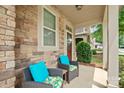 Close-up of front porch seating area with stylish cushions and decorative stone at 7322 Dulnian Way, Charlotte, NC 28278