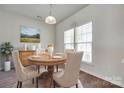 Well-lit dining room featuring a round wooden table, beige chairs, and natural light from the double windows at 764 Atherton Way, Rock Hill, SC 29730