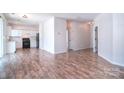 Spacious open-concept living area featuring wood-look floors, seamlessly connecting to the kitchen and dining spaces at 8655 Meadowmont View Dr, Charlotte, NC 28269