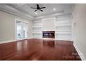 Elegant living room with coffered ceilings, a modern fireplace, built-in shelving, and gleaming hardwood floors at 106 Kelly Marie Ct, Kings Mountain, NC 28086