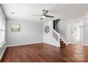 Spacious living room with hardwood floors, a ceiling fan, and staircase access at 11023 Kinston Ridge Pl, Charlotte, NC 28273