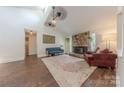 Spacious living room with a stone fireplace, ceiling fans, and hardwood flooring at 11834 Carmel Lakes Dr, Charlotte, NC 28226