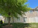 A cozy backyard with a green lawn and a view of the house's rear exterior with a sliding glass door at 12421 Fiorentina St, Charlotte, NC 28277