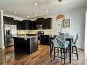 Modern kitchen with dark cabinets, stainless steel appliances, and a central island with wood floor at 12421 Fiorentina St, Charlotte, NC 28277