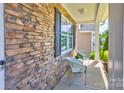 Charming covered front porch featuring stone accents, adorned with two chairs for relaxing at 1325 Grantwood Nw Ave, Concord, NC 28027