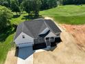 New construction home on a lush green golf course with a large driveway and welcoming front porch at 133 Harbourtown Dr, Kings Mountain, NC 28086