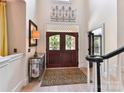 Elegant foyer features a stylish front door, decorative wrought iron detail, and beautiful flooring at 15009 Fanning Manor Ct, Charlotte, NC 28277