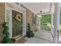 Inviting front porch with brick accents, decorative wreath, and elegant landscaping at 3020 Waxhaw Crossing Dr, Waxhaw, NC 28173