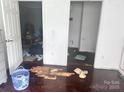 Bedroom with peeling floors, an open door and personal items scattered on the floor at 32891 Nc 49 Hwy, New London, NC 28127
