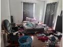 Bedroom with hardwood floors, window, curtains and personal items scattered on the floor at 32891 Nc 49 Hwy, New London, NC 28127