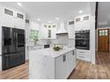 Modern kitchen with white cabinets, a marble island, and stainless steel appliances at 402 Wildlife Rd, Troutman, NC 28166