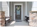 Close up of a home's cozy front porch with stone accents and a decorative wreath on the front door at 4116 Tory Path Rd, Waxhaw, NC 28173